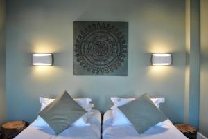 a bed with two pillows and a picture on the wall at Guest House Santa Clara in Coimbra