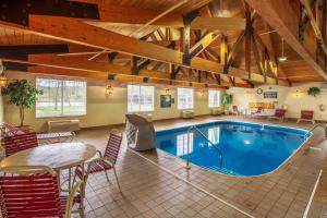a pool in a room with a table and chairs at Coshocton Village Inn & Suites in Coshocton