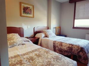 מיטה או מיטות בחדר ב-Hostal Galicia Arteixo