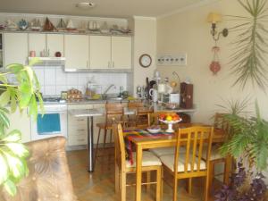 Departamento Torres del Mar de Dichato في ديخاتو: مطبخ وغرفة طعام مع طاولة وكراسي
