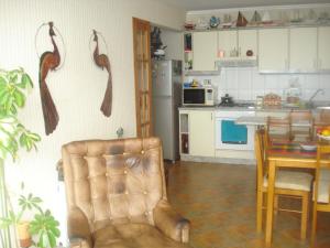 uma cozinha com uma mesa e uma cadeira num quarto em Departamento Torres del Mar de Dichato em Dichato