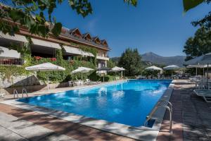 a pool at a hotel with chairs and umbrellas at Hotel Rural Las Gacelas in Becerril de la Sierra