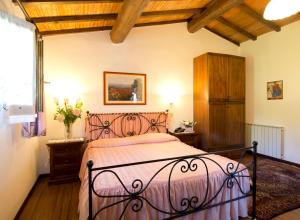 1 dormitorio con 1 cama en una habitación con techos de madera en Hotel Il Pietreto, en Colle Val D'Elsa