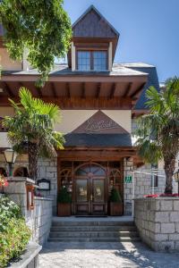 una casa con una puerta delantera con palmeras en Hotel Rural Las Gacelas en Becerril de la Sierra