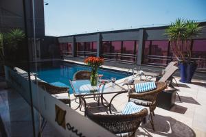 a patio with a table and chairs next to a pool at Hotel Golden Park Campinas Cambuí in Campinas