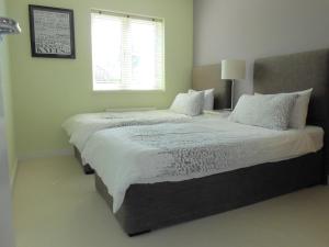 a bedroom with two beds and a window at Sunnybank House in North Epsom in Epsom