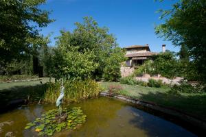 コッレ・ディ・ヴァル・デルザにあるHotel Il Pietretoの池鳥像のある庭園