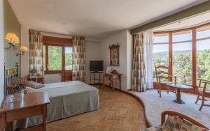 a hotel room with a bed and a balcony at Hotel Rural Las Gacelas in Becerril de la Sierra