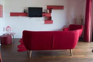 a red couch in a living room with a tv at Immeuble La Mer in Porto-Vecchio