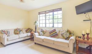 
a living room filled with furniture and a window at Addison Lee Cayman Villa in George Town
