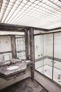 a bathroom with a tub and a sink and a shower at Hotel Golden Park Campinas Cambuí in Campinas