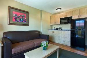 a living room with a couch and a kitchen at Oxford Suites Lancaster in Lancaster