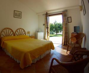 a bedroom with a yellow bed and a sliding glass door at Agriturismo Valle Siriaca in Castelnuovo di Porto