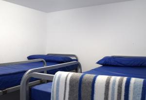 two beds in a room with blue pillows on them at Albergue Santiago Apostol in Logroño