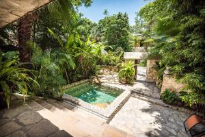 einen Pool inmitten eines Gartens in der Unterkunft Hotel Boutique Quinta Chanabnal in Palenque