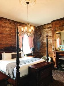 Un dormitorio con una cama grande y una lámpara de araña. en Lafitte Hotel & Bar, en Nueva Orleans