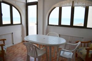 デニアにあるCabañas 3 LOCDENIAの窓付きの客室で、白いテーブルと椅子が備わります。