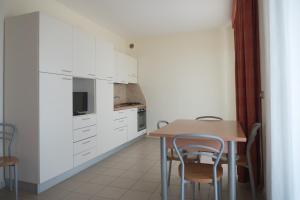 a kitchen with white cabinets and a table and chairs at Casa Del Mar in Roseto degli Abruzzi