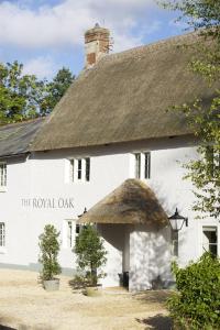 a white building with a thatched roof at The Royal Oak in Anstey