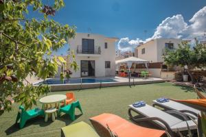 an image of a backyard with chairs and tables at Artemisia Villa in Protaras