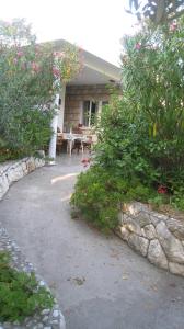 uma casa com uma mesa de piquenique e alguns arbustos em Barko apartment and rooms em Hvar