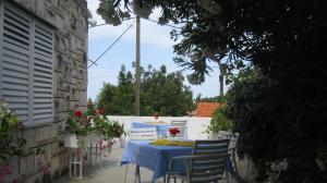a table with a blue table cloth and chairs on a patio at Barko apartment and rooms in Hvar