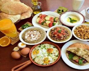 a table topped with plates of breakfast foods and drinks at Al-Houriat Hotel in Amman