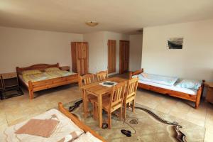 a room with two beds and a table and chairs at Penzion Krasula in Ždiar