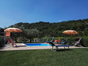 een zwembad met 2 ligstoelen en 2 parasols bij Brigida in Verucchio