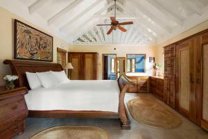 una camera da letto con un letto e un ventilatore a soffitto di The Caves a Negril