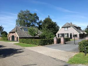 une maison avec une clôture et une allée dans l'établissement Vakantiehuis Ganderhoeve, à Gaanderen