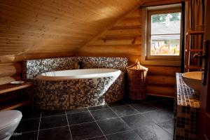 La salle de bains est pourvue d'une baignoire et d'un lavabo dans une cabine. dans l'établissement Srub Bublava 806, à Bublava