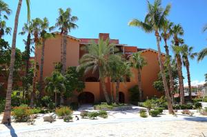 a building with palm trees in front of it at Dunas 102 in Cabo San Lucas