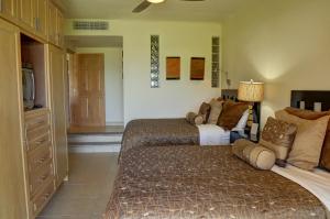 1 dormitorio con 2 camas y TV. en Dunas 102, en Cabo San Lucas