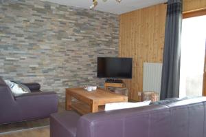 a living room with two purple couches and a tv at "Chalet le Dahlia - 4 Vallees" in Les Collons