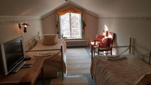 a bedroom with a bed and a tv and a table at Taulun Kartano in Kankainen