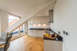 a kitchen with white cabinets and a counter top at Hampden Apartments - The Victoria in Windsor