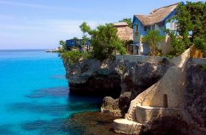 a house on a cliff next to the ocean at The Caves in Negril