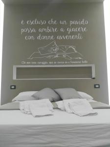 a bedroom with a bed with a quote on the wall at B&b Next Stop Napoli in Naples