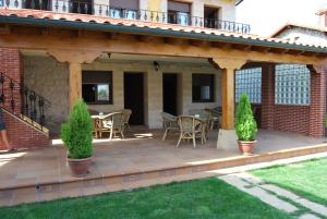 una casa con un patio al aire libre con sillas y mesas. en Apartamentos Casa Bernabé, en Miengo