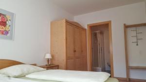 ブレッサノーネにあるKienasthofのベッドルーム1室(ベッド1台付)、木製キャビネットが備わります。
