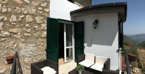 une maison avec une porte verte et 2 chaises blanches dans l'établissement Casa Sarlo, à Petina