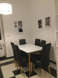 ein Esszimmer mit einem weißen Tisch und schwarzen Stühlen in der Unterkunft Classic Deluxe Apartman in Zagreb