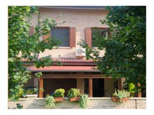 a house with potted plants on the front of it at Alloggio al Naviglio in Copparo