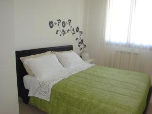 a bedroom with a bed with a green blanket at Alloggio al Naviglio in Copparo