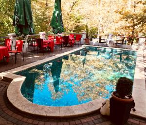 uma piscina com mesas e cadeiras ao lado em Villa Bella Boutique Hotel em Kavadarci