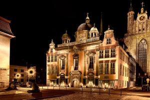 a large building with a clock tower at night at Apartament Kameralny 17 in Gdańsk