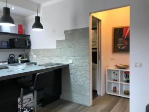 uma cozinha com um balcão e uma parede de tijolos em Kibilù - Via Confalonieri - Stazione Garibaldi - Zona Isola em Milão