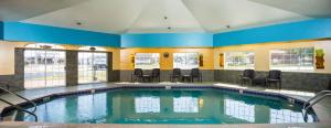 a swimming pool with chairs in a building at Hotel J Green Bay in Green Bay