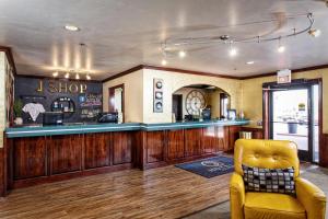 a bar in a restaurant with a yellow chair at Hotel J Green Bay in Green Bay